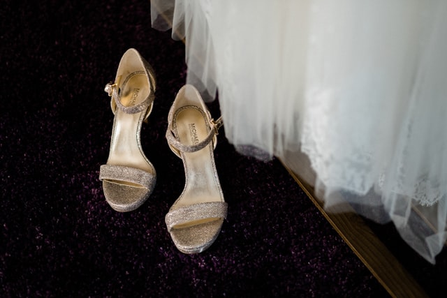 brokatowe buty ślubne i biała suknia ślubna