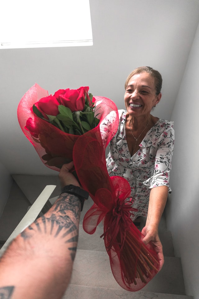 syn daje mamie czerwone róże na dzień matki