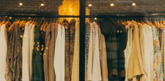 brązowe, beżowe i kremowe swetry na wieszaku w sklepie